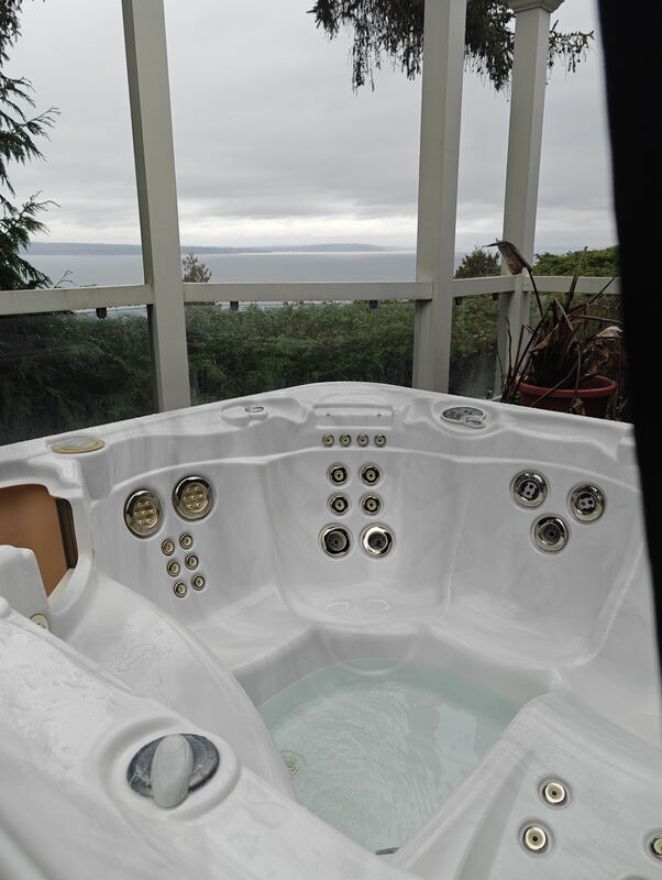 Pristine spa under a white pergola overlooking Puget Sound
